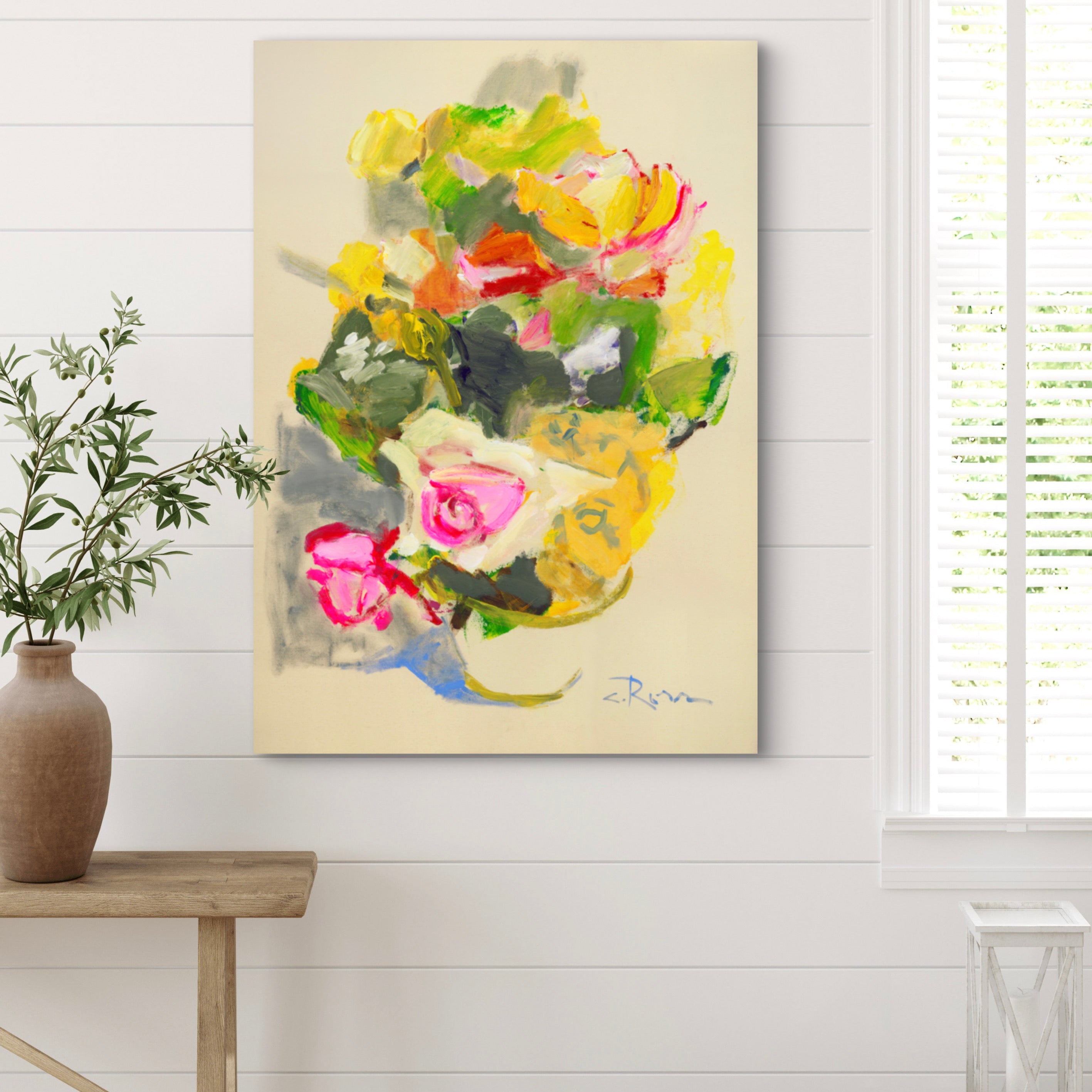 Colorful abstract painting on a wall with a wooden table and plant in the foreground.